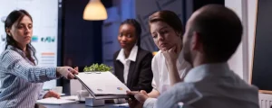 Collaborateurs d'entreprise analysant un dossier stratégique et des graphiques pour ancrer une culture du changement en PME.