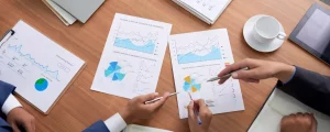 Analyse de données d'entreprise, de graphiques d'activité et de KPI sur des documents papier lors d'une session de pilotage stratégique.