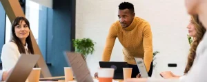 Formateur animant un atelier collaboratif en entreprise pour guider les équipes vers une meilleure adoption des usages applicatifs.