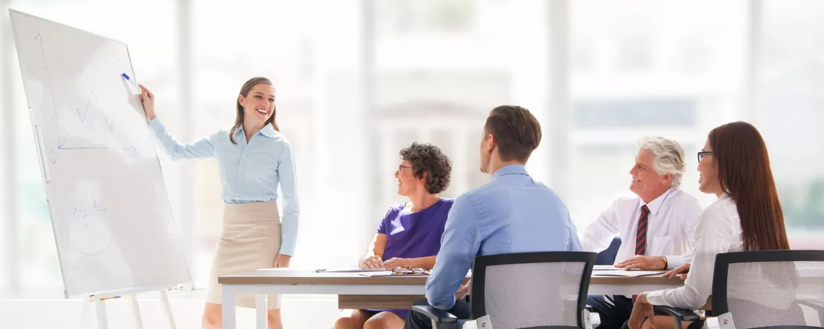 Animatrice expliquant un plan de réussite stratégique lors d'une séance de formation continue pour professionnels.