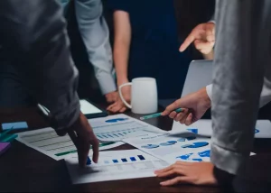 Équipe d'entreprise analysant des graphiques de performance lors d'une réunion stratégique pour l'application du modèle ADKAR en PME.